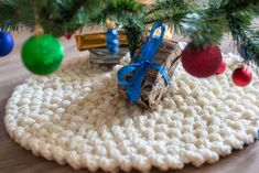 a crocheted christmas tree skirt with blue ribbon