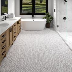 a bathroom with a tub, sink and large window in it's center area