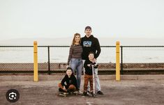 a family poses for a photo in front of the ocean with their skateboarders