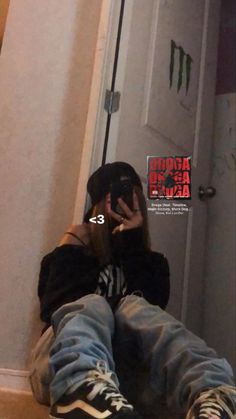 a person sitting on the floor taking a selfie in front of a bathroom mirror