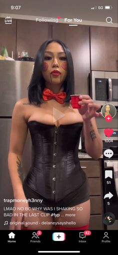 a woman wearing a corset and red bow tie holding a cup in her hand