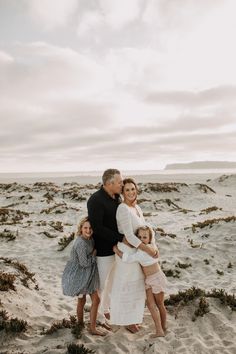 a family poses for a photo on the beach