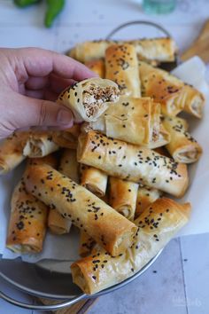 a person is holding some bread rolls in their hand and they are on a plate