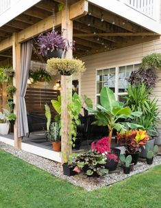 an outdoor covered patio with potted plants on the ground and in front of it