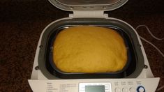 a loaf of bread sitting in an oven on top of a counter next to a digital thermometer