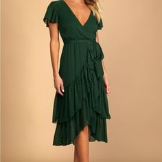 a woman wearing a green dress with ruffles