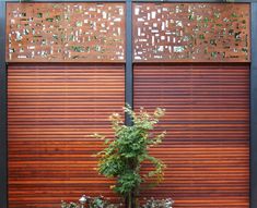 a plant in a pot next to a wooden wall with metal slats on it