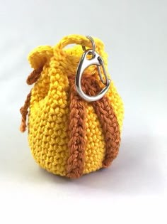 a small crocheted purse with a metal ring hanging from it's side