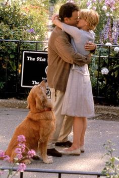 a man and woman kissing in front of a dog