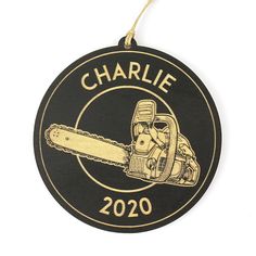 a black and gold ornament with a chainsaw on it