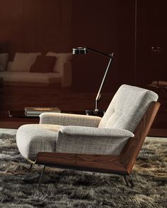 a chair with a lamp on top of it sitting in front of a couch and coffee table