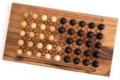 a wooden board game with black and white balls