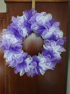 a purple and white mesh wreath on a wooden door