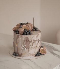 a birthday cake decorated with blueberries and cookies