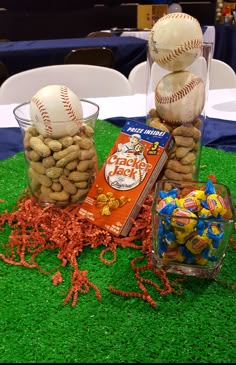 baseballs, peanuts and candy are sitting on the grass in front of a table