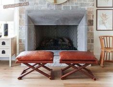 a living room scene with focus on the fireplace and two benches in front of it