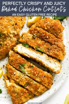 chicken cutlets on a white plate with lemon wedges and parmesan cheese