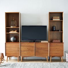 an entertainment center with shelves and a flat screen tv