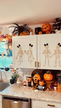 a kitchen decorated for halloween with skeletons and pumpkins