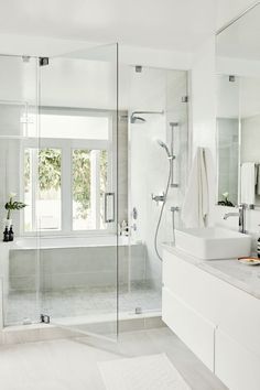 a white bathroom with glass shower doors