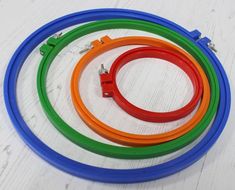 four different colored hoses on a white table with one being connected to the other