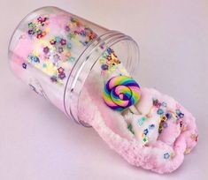 a jar filled with candy and sprinkles on top of a white table