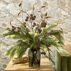 a vase filled with flowers sitting on top of a table next to a green chair