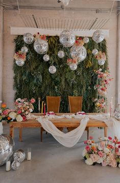 the table is set with flowers, candles and hanging decorations for an elegant wedding reception