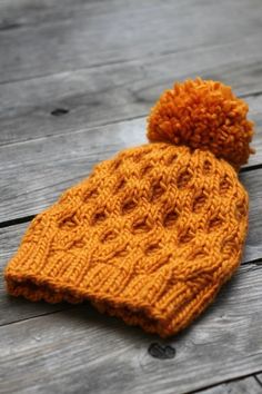 an orange knitted hat with a pom - pom