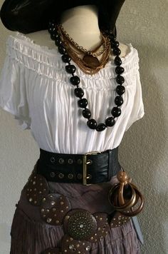 a mannequin wearing a white shirt and brown skirt with black beads on it