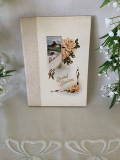 an old fashioned photo frame with flowers on it and two white doves next to it