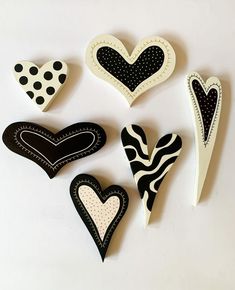 several different shapes and sizes of hearts on a white surface with polka dots, zebra print, and black spots