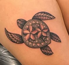 a woman's thigh with a turtle tattoo on the back of her leg and flowers in the center