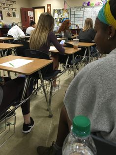 several people sitting at desks in a classroom