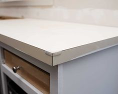 a white counter top with drawers in the middle and an open drawer on the side