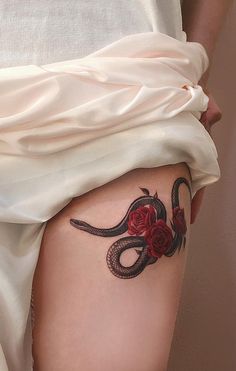 a woman's thigh with a tattoo on it and a snake in the middle