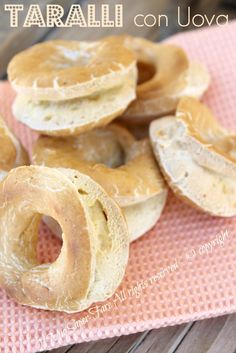 several bagels sitting on top of a pink mat with the words taralli on it