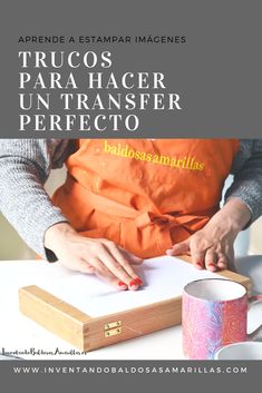 a woman in an orange apron is cutting paper on a table with coffee mugs