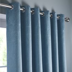 a blue curtain with silver rods hanging from it's side in front of a window