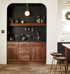 a kitchen with black brick walls and wooden cabinets, gold accents on the countertops