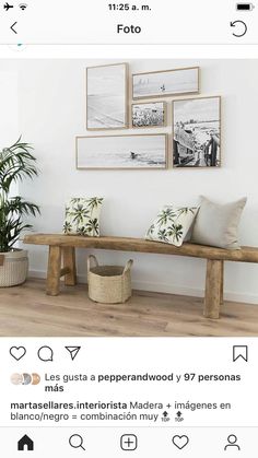 a wooden bench sitting next to a wall with pictures hanging on it's side