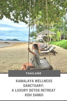 a woman sitting on top of a swing in the middle of a tree filled beach