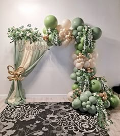 a balloon arch with green and white balloons