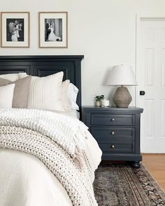 a bed with white sheets and pillows in a bedroom next to two pictures on the wall