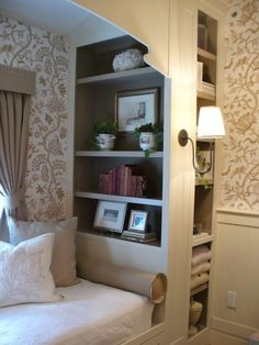 a room with a bed, bookshelf and pictures on the shelves in it