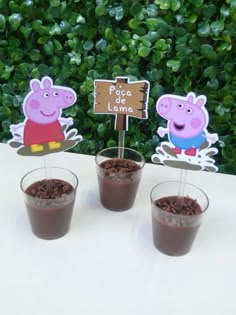 three cups filled with chocolate pudding sitting on top of a table