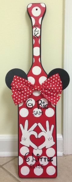 a red and white wine bottle with minnie mouse ears on it's head is decorated with polka dots