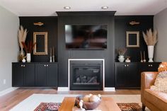 a living room with couches and a television mounted on the wall above a fireplace