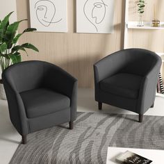 two black chairs sitting next to each other on top of a rug