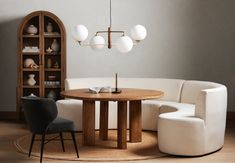 a living room filled with furniture next to a book shelf and lamp hanging from the ceiling